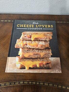The Cheese Lovers Cookbook - Black Cover with Cheddar Grilled Cheese Image